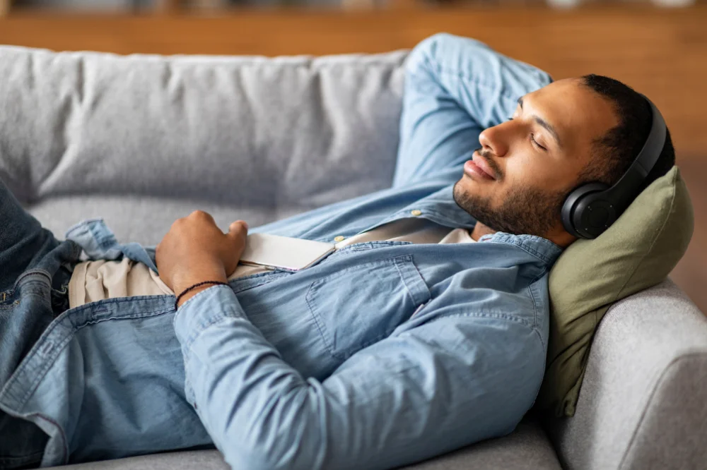 Man resting on a couch in a meditative position