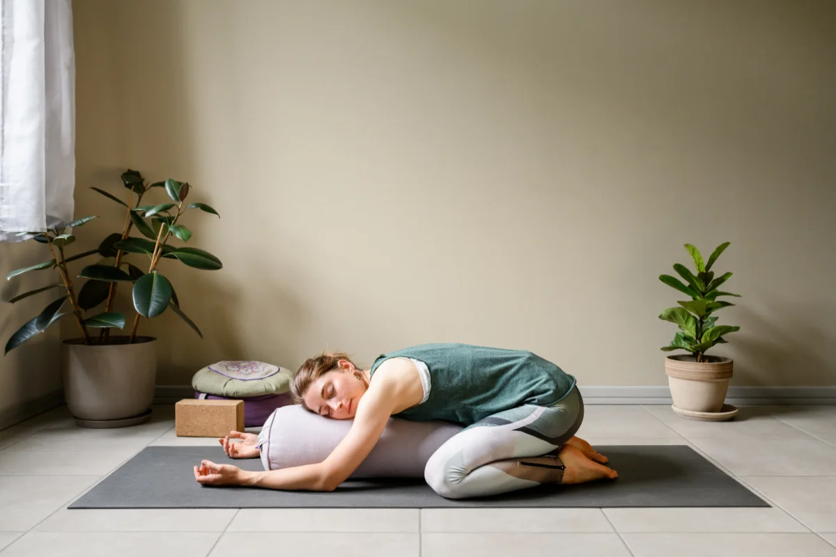 Woman resting in a supported, restorative pose during a pacing break.
